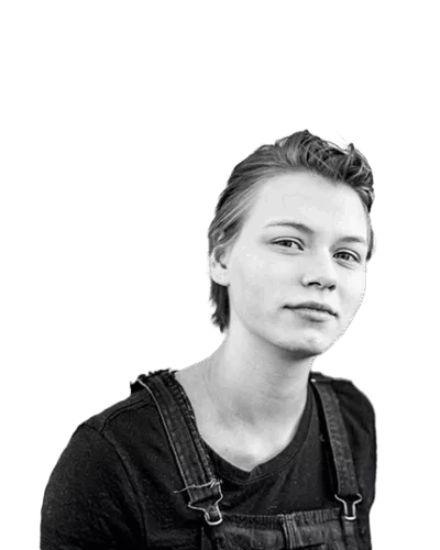 Confident young person looking directly at the camera, wearing overalls