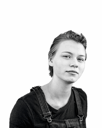 Confident young person looking directly at the camera, wearing overalls