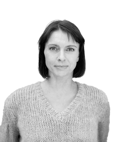 Black and white portrait of a woman with straight dark hair, wearing a textured knitted sweater and facing the camera with a calm expression.