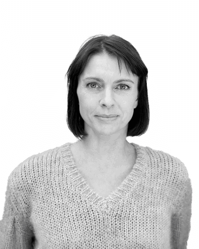 Black and white portrait of a woman with straight dark hair, wearing a textured knitted sweater and facing the camera with a calm expression.