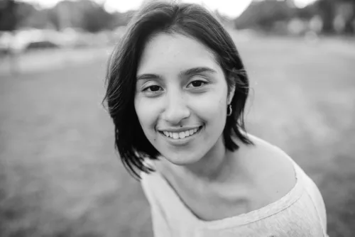 young woman smiling outdoors, symbolizing accessible healthcare for all